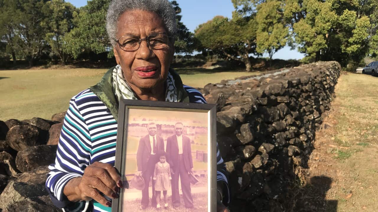 Aunty Lill Engstrom carries a photo of her father by the wall he build about 120 years ago. 