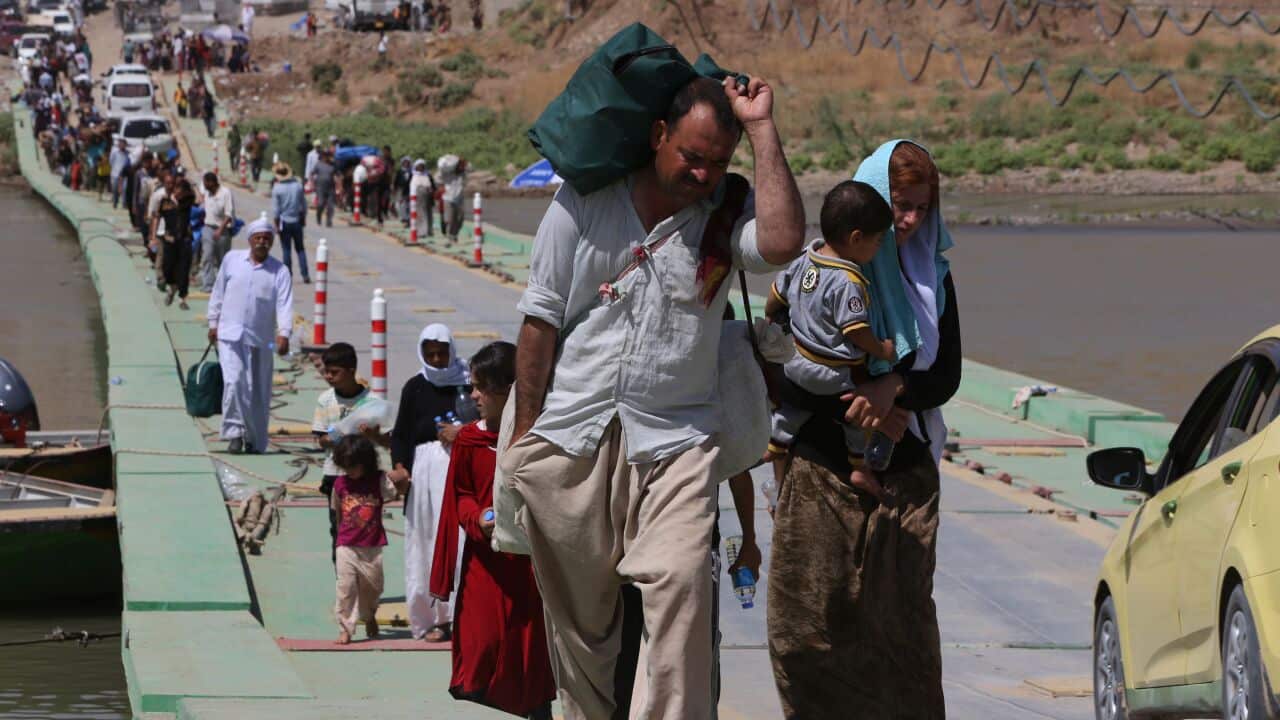 Displaced Iraqis from the Yazidi community cross the Iraqi-Syrian border along the Fishkhabur bridge over the Tigris River at the Fishkhabur crossing, in northern Iraq. (AFP/AHMAD AL-RUBAYE)