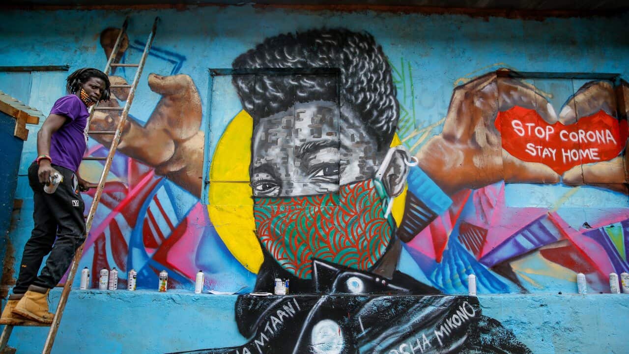 Brian Musasia Wanyande, a graffiti artist from the Mathare Roots youth group, works on an informational mural warning people about the risk of coronavirus.