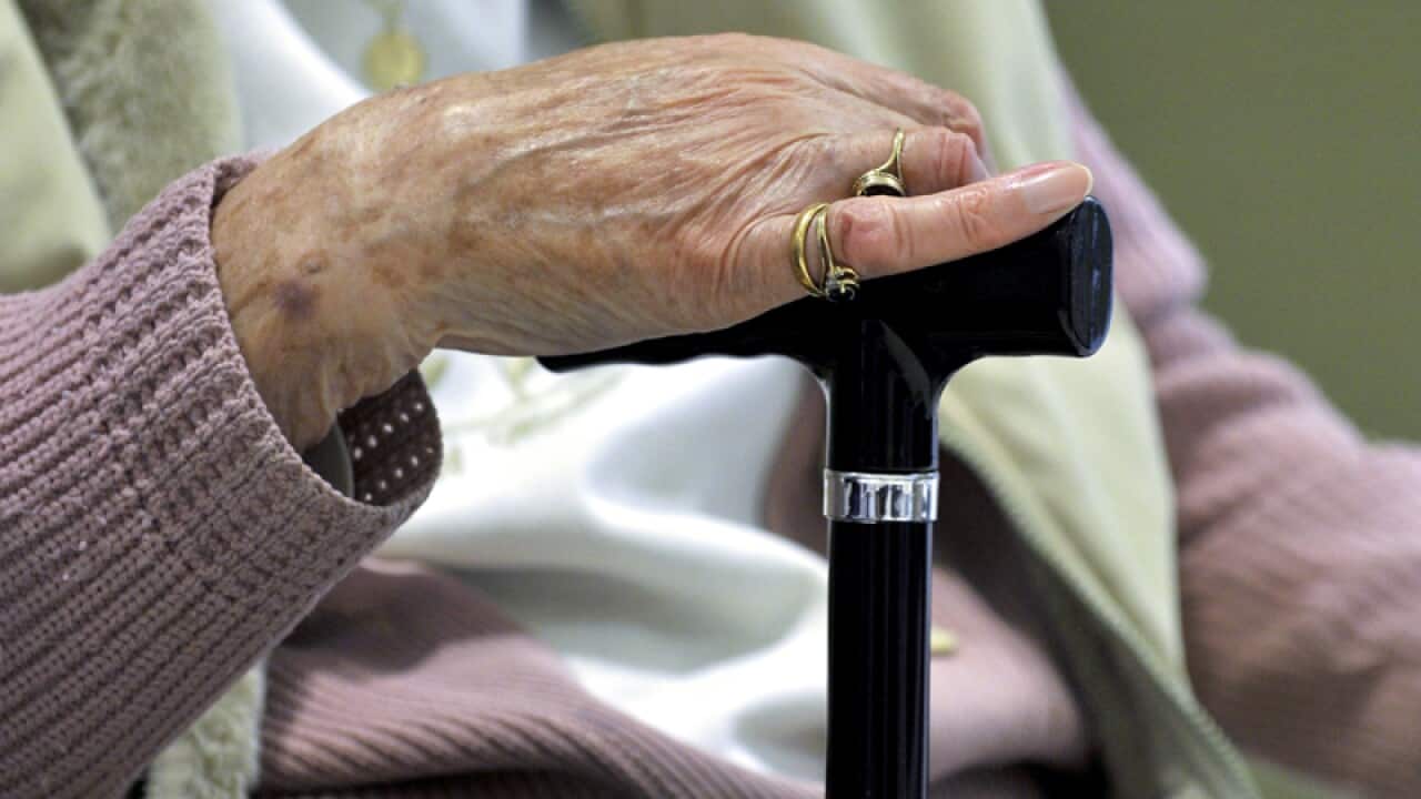A woman uses a walking stick to assist her mobility in Canberra