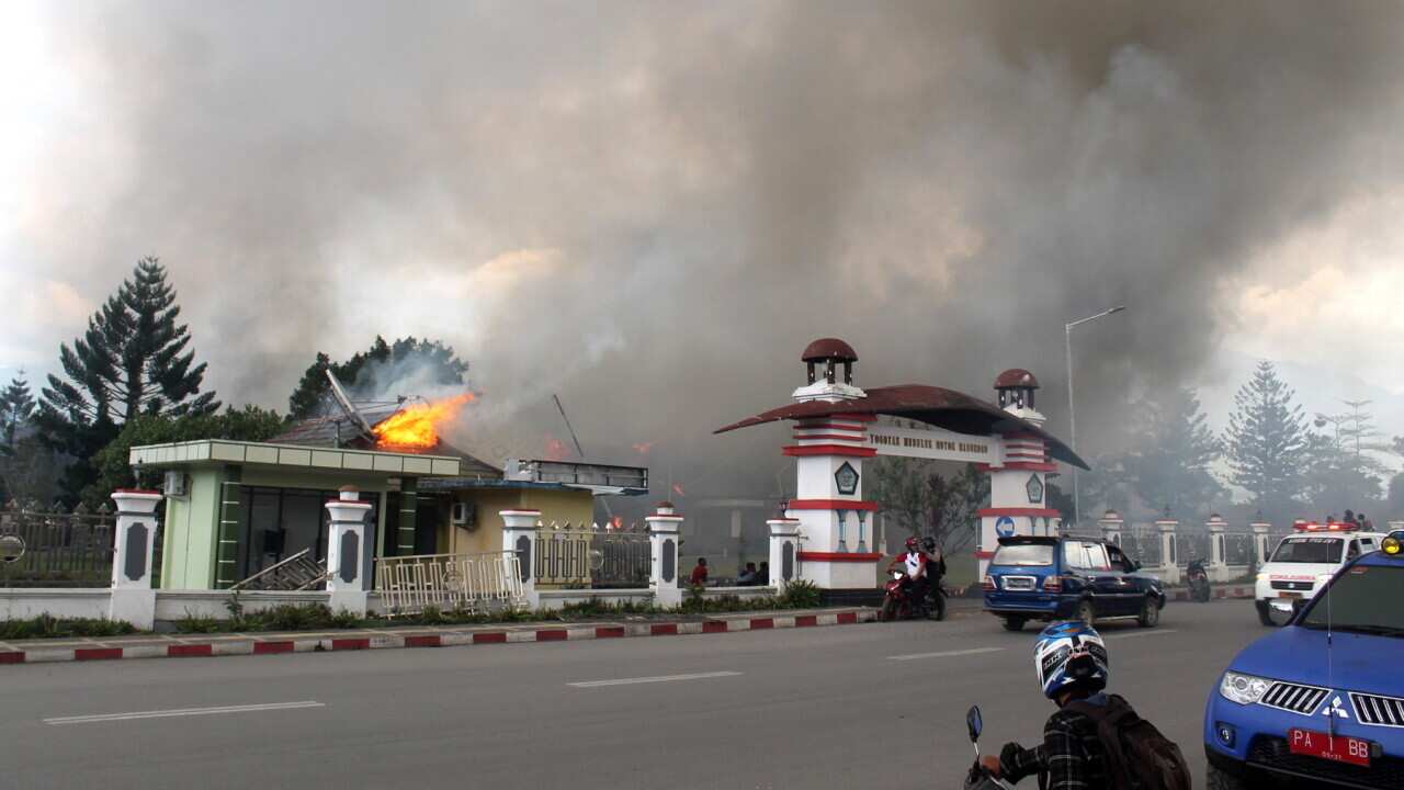 Smoke rises from a burning building during a violent rally in Wamena, Papua Province