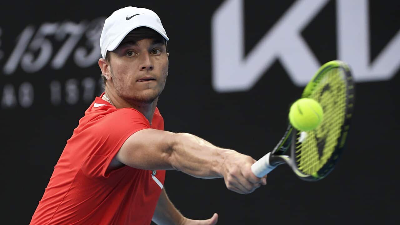 Miomir Kecmanovic of Serbia makes a backhand return to Gael Monfils of France during their fourth round match at the Australian Open tennis championships in Melbourne, Australia, Sunday, Jan. 23, 2022. (AP Photo/Andy Brownbill)