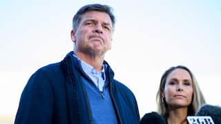 A middle-aged white man frowning. A white stands beside him.