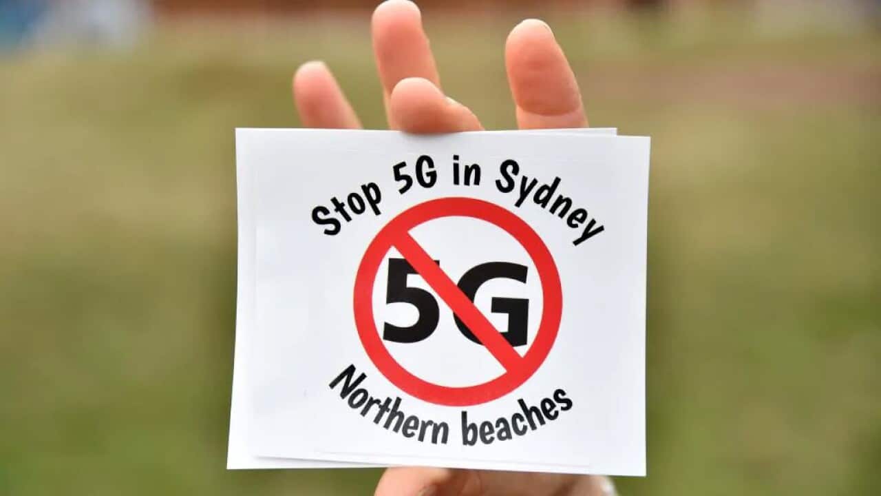 Anti 5G sticker being held by a member of Stop 5G Northern Beaches group.
