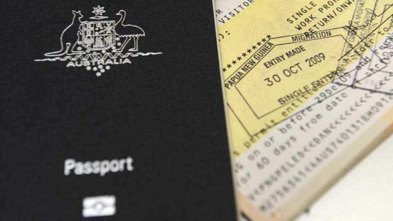 An Australian passport is pictured next to an entry visa to Papua New Guinea in Brisbane