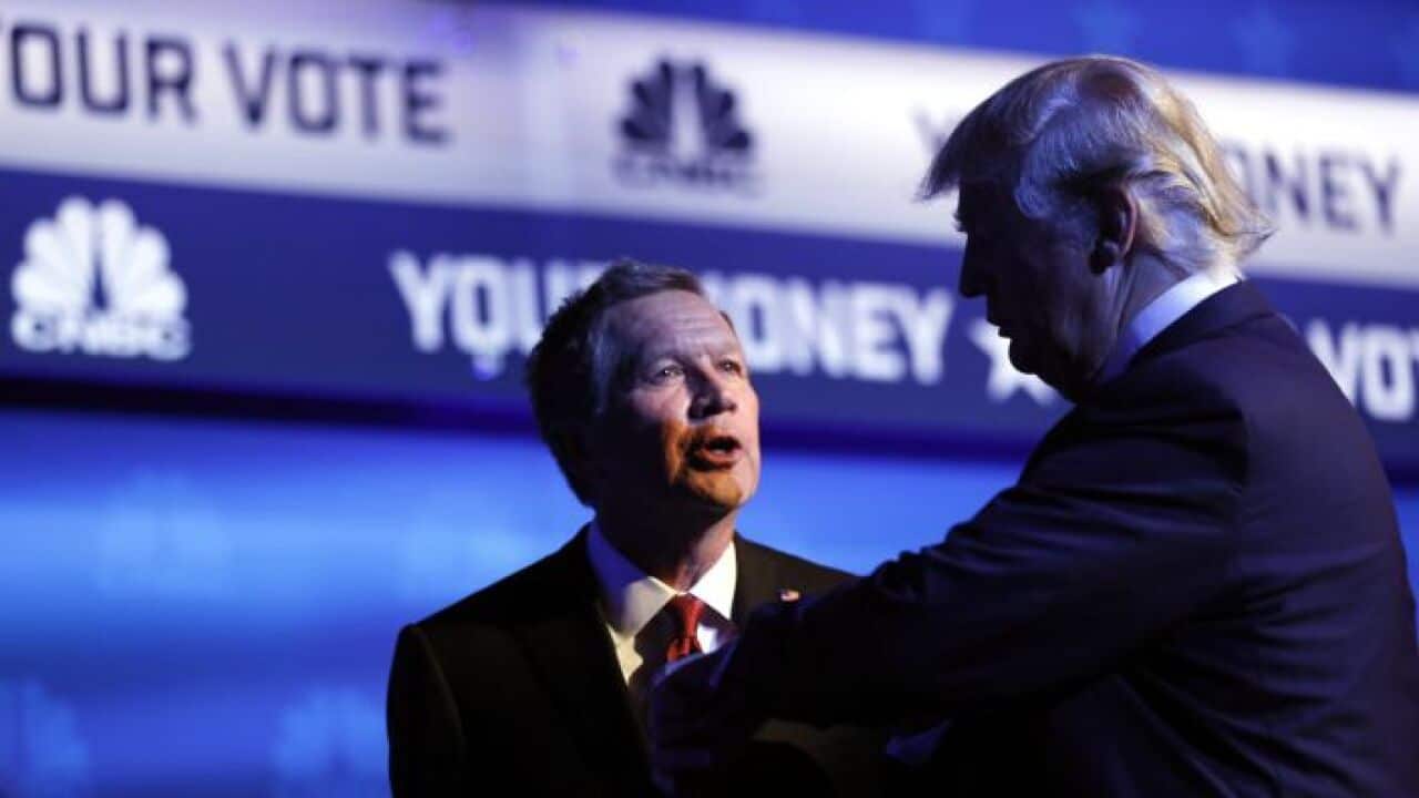 Republican U.S. presidential candidate and Ohio Governor John Kasich (L) talks with businessman Donald Trump (R)