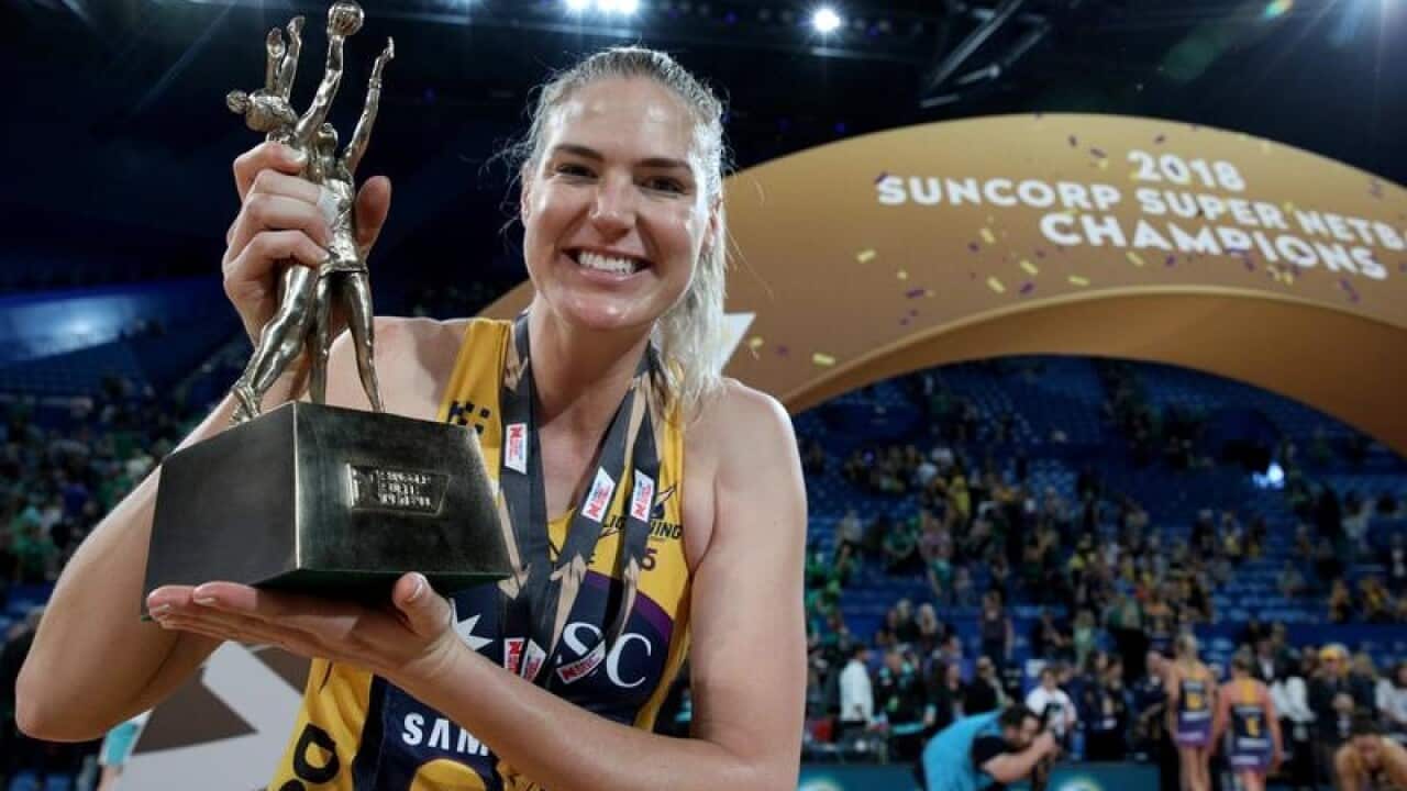 Caitlin Bassett of the Lightning holds the Super Netball trophy.
