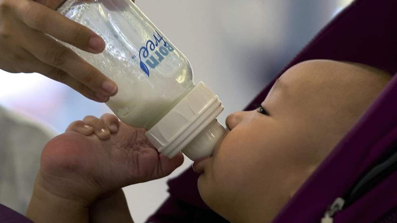 A baby is fed milk from a bottle