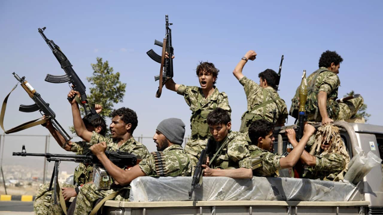 Houthi rebels ride on a patrol truck
