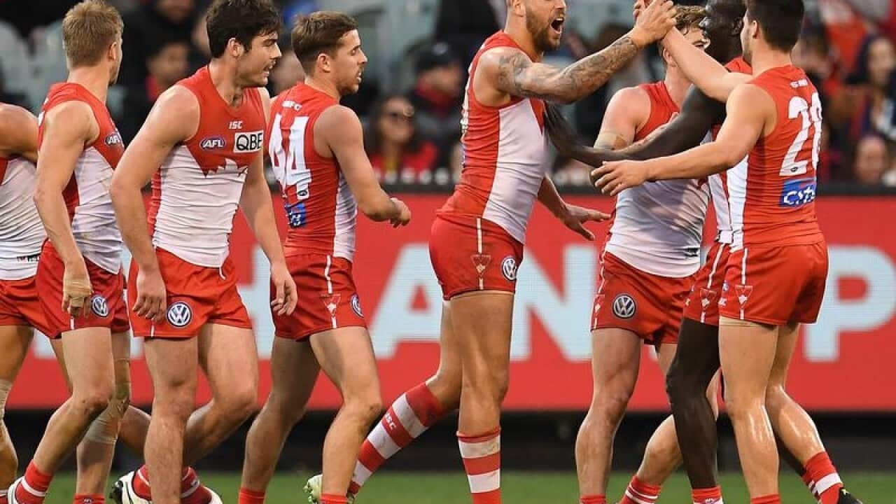 Lance Franklin of the Swans (4R) reacts after kicking a goal