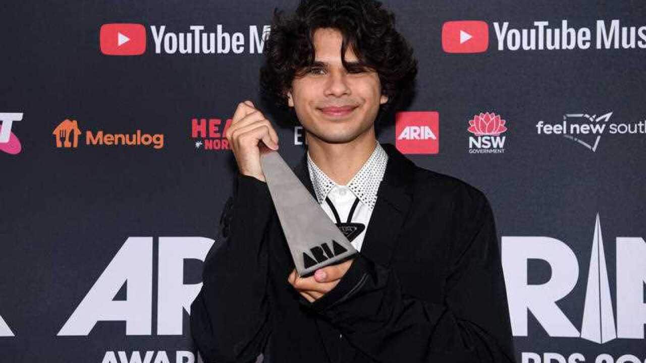 Budjerah smiles holding his newly-won ARIA at the ceremony.
