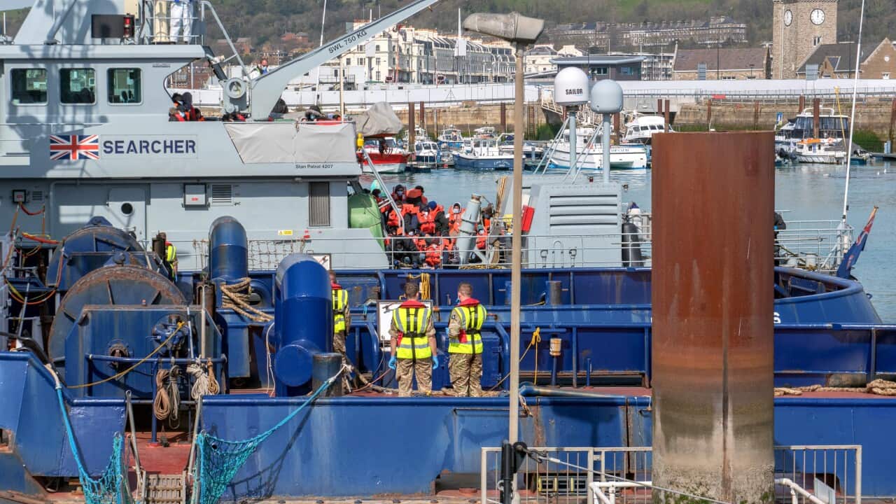 Migrants escorted by Border Force officers after crossing the English Channel in Dover, Britain