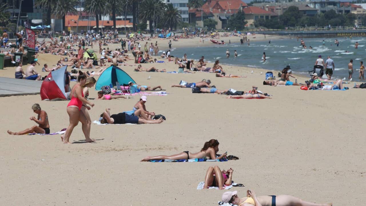 People soak up the sun at St Kilda beach in Melbourne on January 25.