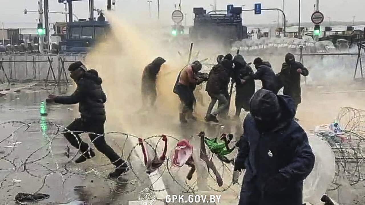 Polish servicemen use a water cannon during clashes between migrants gathering at the checkpoint "Kuznitsa" at the Belarus-Poland border.