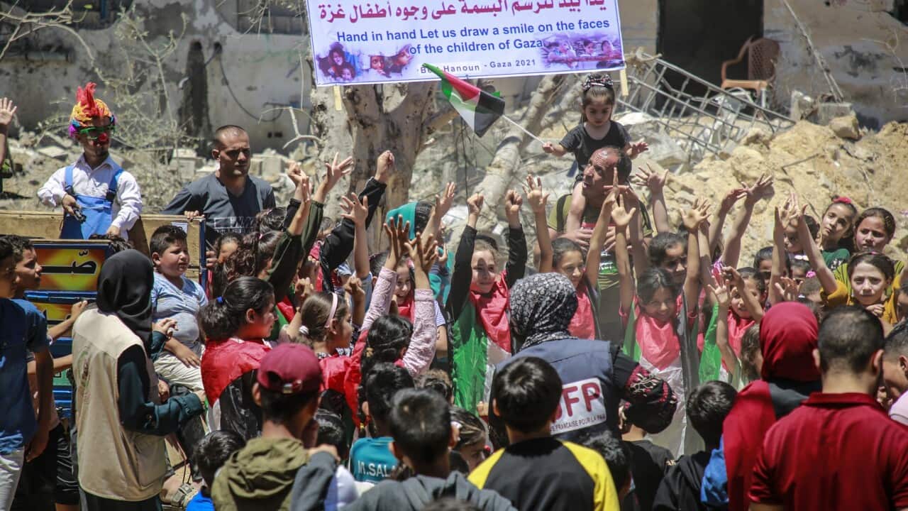 Palestinian children play next to buildings damaged by air strikes in northern Gaza