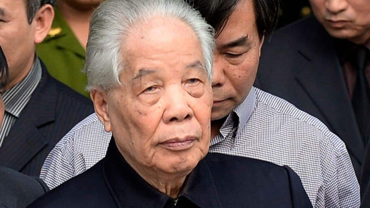 Former Communist Party Secretary General Do Muoi, front center, is helped to walk to pay respects to late Gen. Vo Nguyen Giap at the National Funeral House in Hanoi, Vietnam