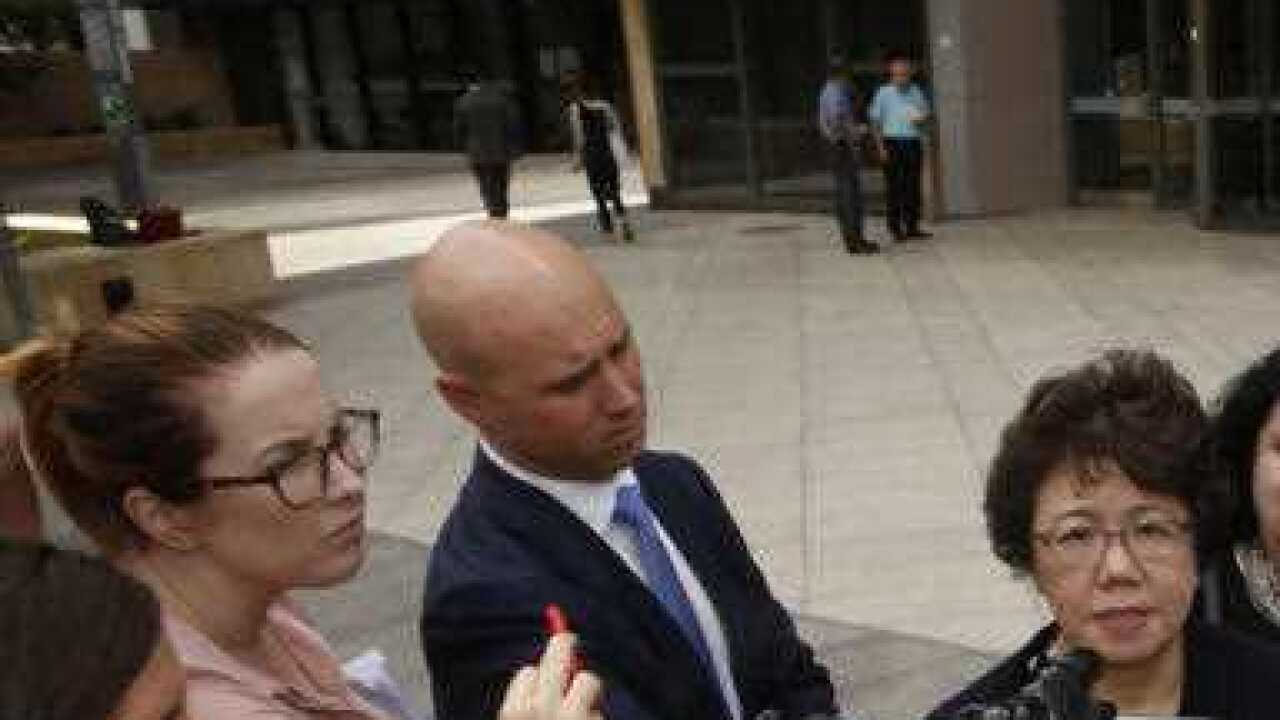 Curtis Cheng's son Alpha Cheng (center right) and widow Selina Cheng (centre left) speak to the media outside Parramatta District Court in Sydney.