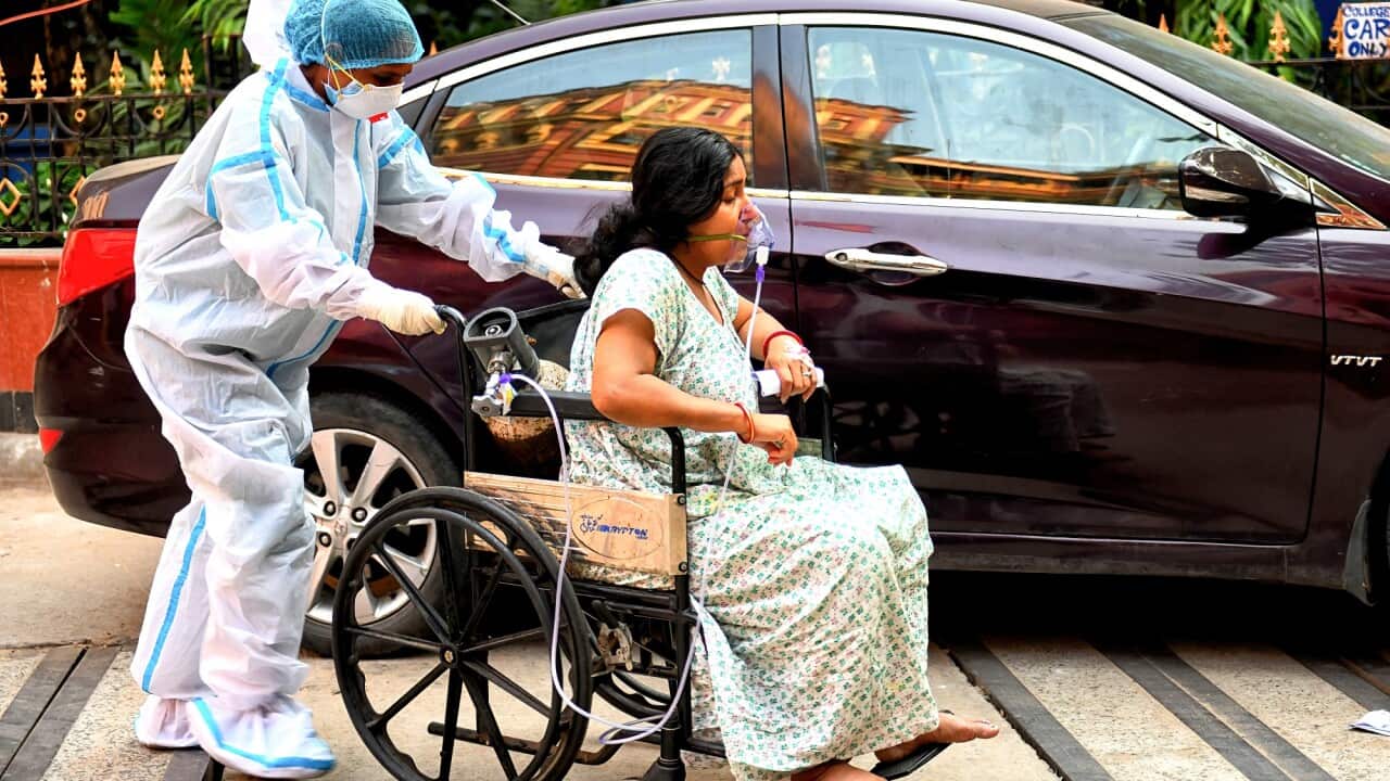 A COVID-19 patient on a wheelchair gets admitted at Kolkata Medical College Hospital in India.