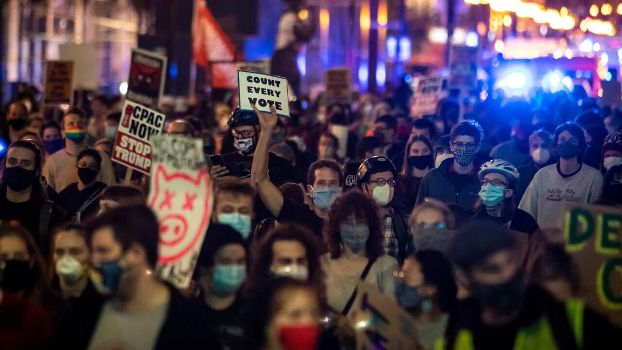 Protesters march through the Loop to demand every vote be counted in the general election, Wednesday night, Nov. 4, 2020. (Ashlee Rezin Garcia/Chicago Sun-Times via AP)