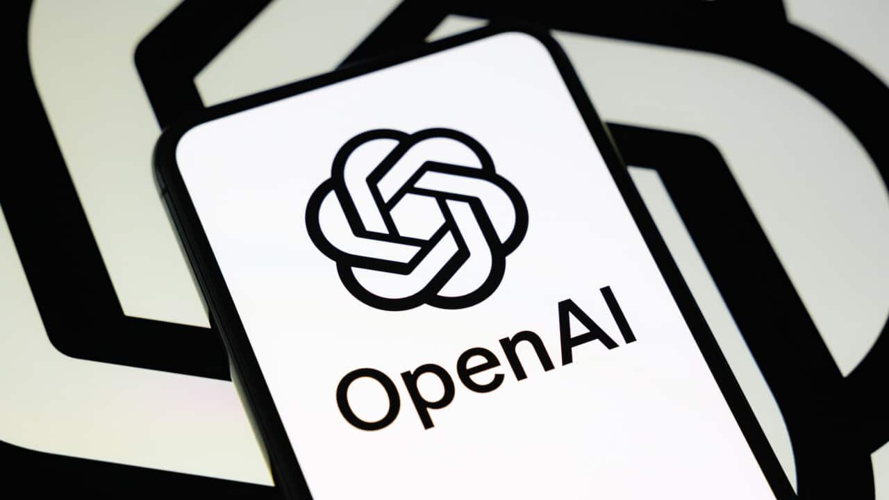 Smartphone displaying the OpenAI logo and name against a black-and-white OpenAI branded background.