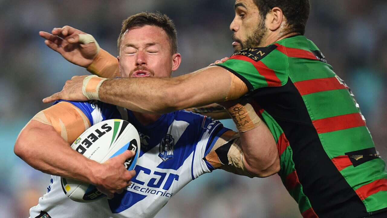 Damien Cook of the Bulldogs is tackled by Greg Inglis of the Rabbitohs