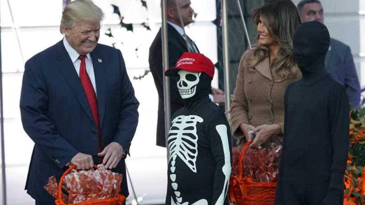The Trumps hand out treats as they welcome children from the Washington area.