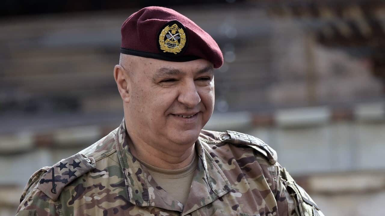 A man wearing an army uniform smiles.