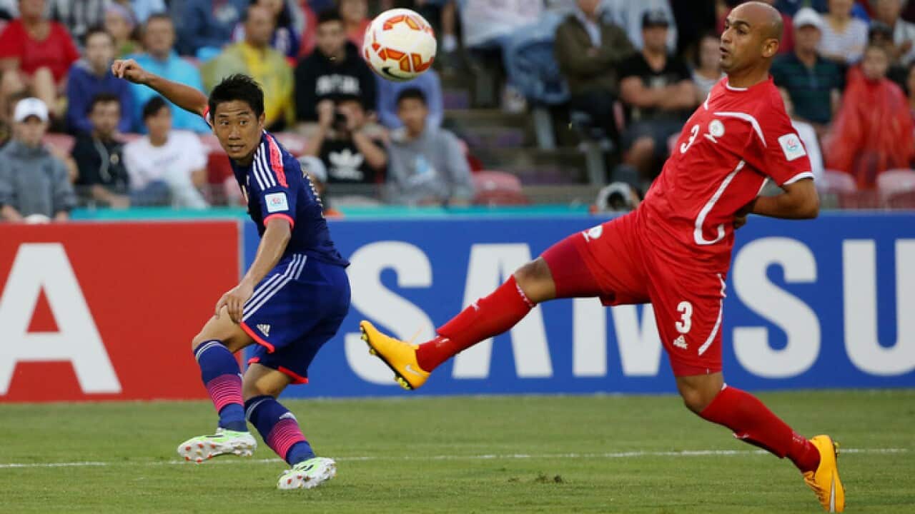 japans_shinji_kagawa_left_and_palestines_husam_abusalah_-_aap-001.jpg