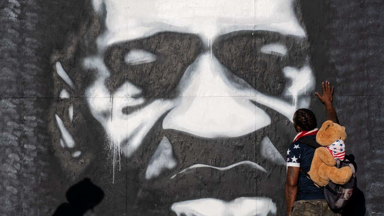 Michael Wilson, 39, of Minneapolis puts his hand on a mural of the late George Floyd on Tuesday, 25 May, 2021 in Minneapolis.