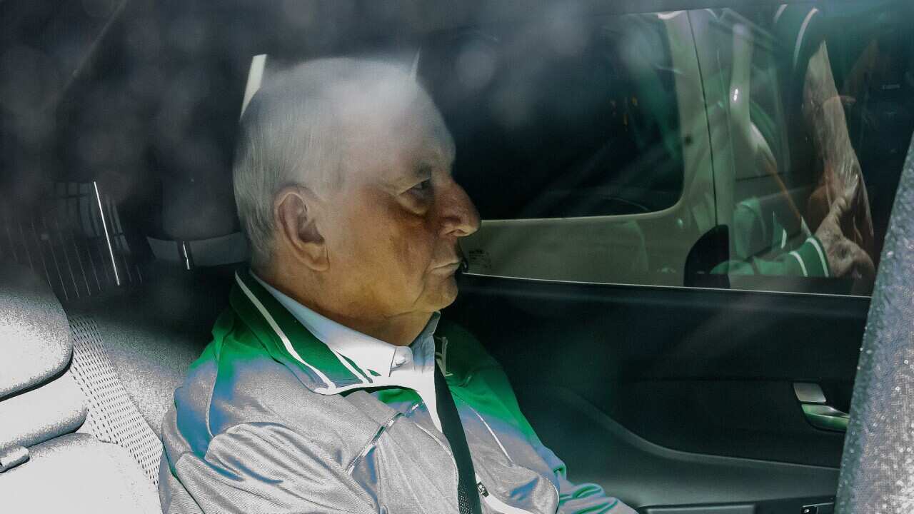 Alan Jones is seen in the back of an unmarked police car as he is transferred to Day St Police Station, in Sydney, Monday, November 18, 2024.