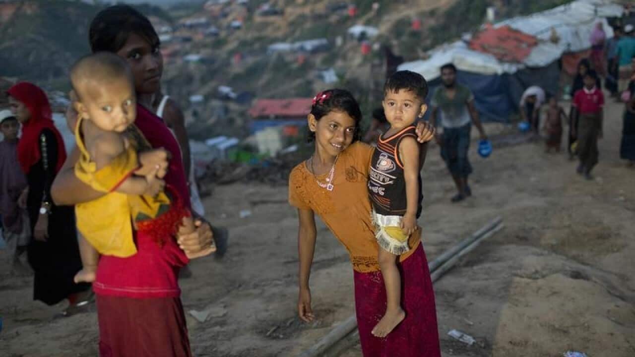 Rohingya Muslim children carrying babies in Hakim Para refugee camp.