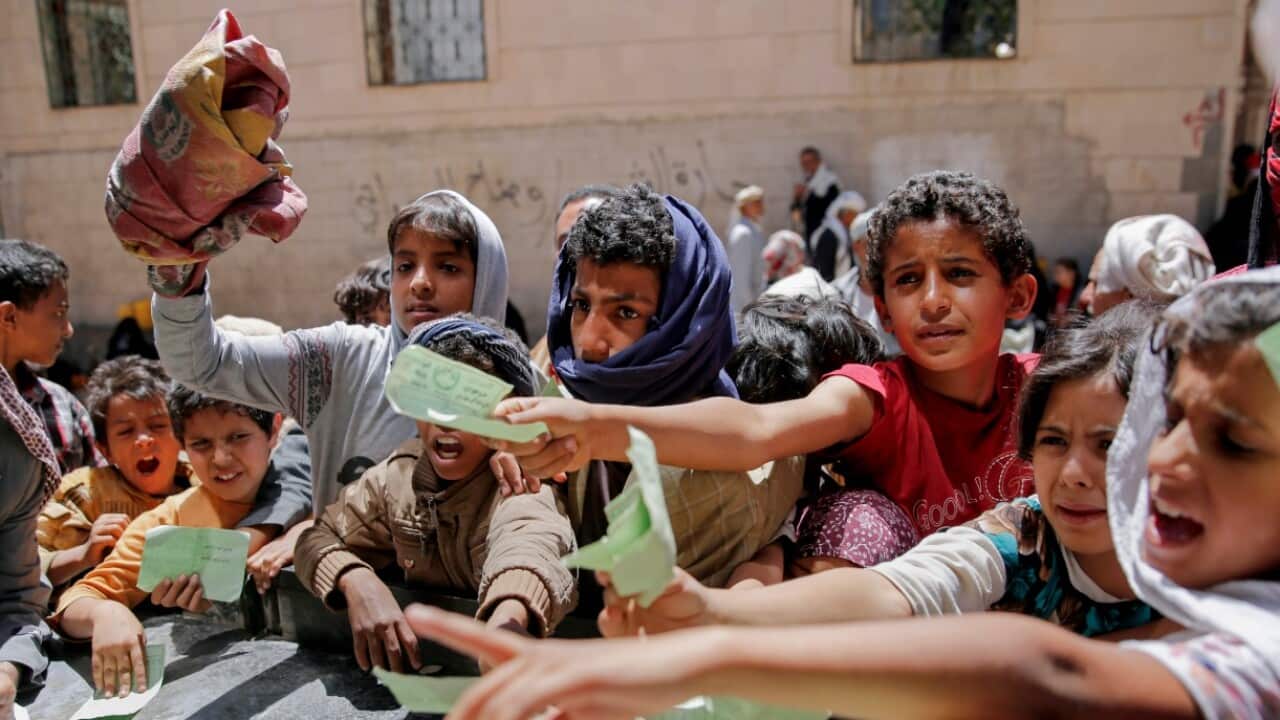 Yemenis present documents in order to receive food rations provided by a local charity, in Sanaa, Yemen, Thursday, April, 13, 2017.
