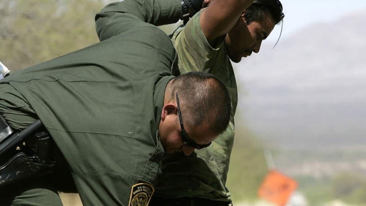 A U.S. Border Patrol agent searches a migrant.