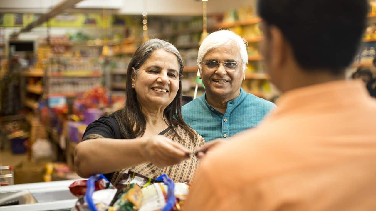 Senior couple paying at store counter