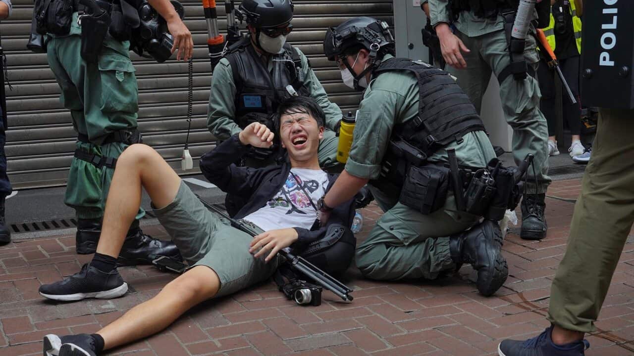 A reporter falls after being sprayed with pepper spray by police on 1 July, 2020.
