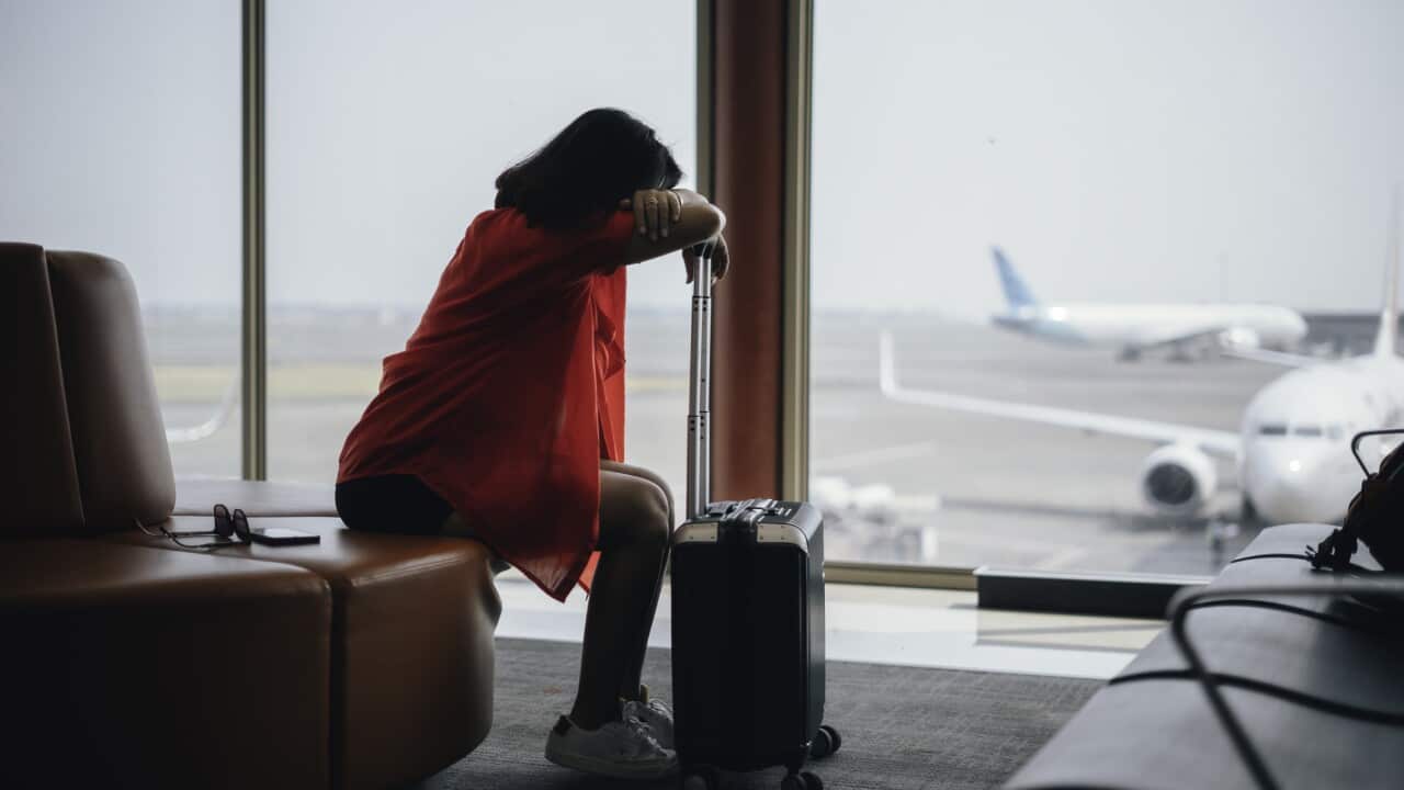 Frustrated young woman business traveler waiting in airport