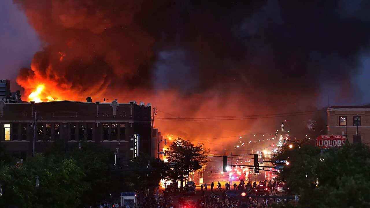 Seen from Hiawatha Avenue, a large fire burns Thursday, May 28, 2020, in Minneapolis during a third night of unrest following the death of George Floyd while in Minneapolis police custody Monday. (David Joles/Star Tribune via AP)