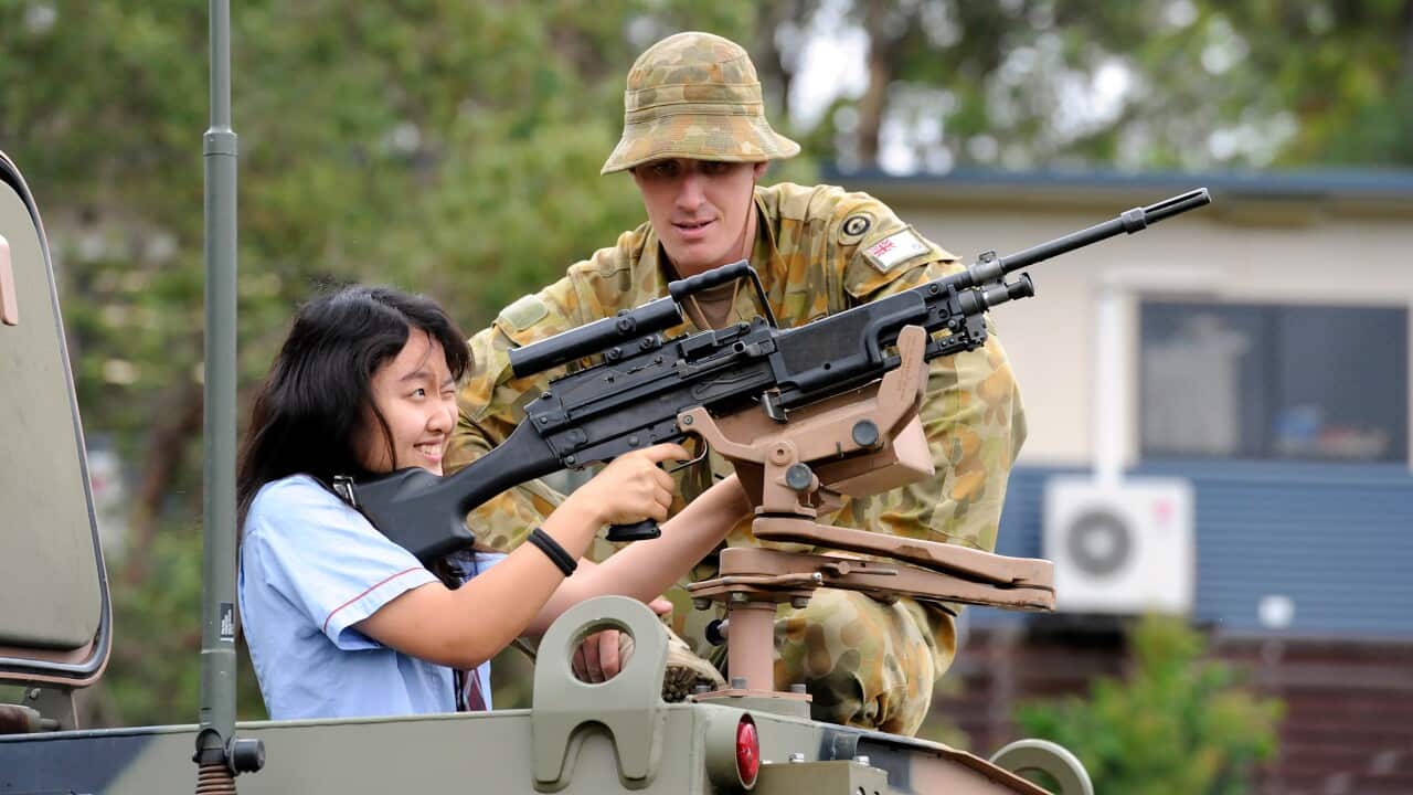 A high school student inspects a machine gun on an Army Bushmaster vehicle in Brisbane - AAP-1.jpg