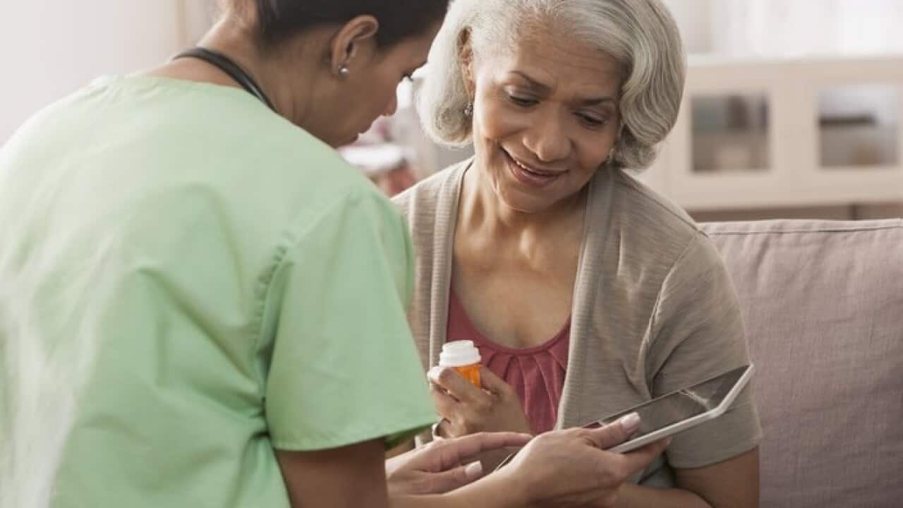 Nurse and older patient using tablet computer