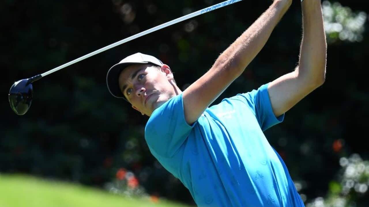 Anthony Quayle of Australia tee's off on a golf course.