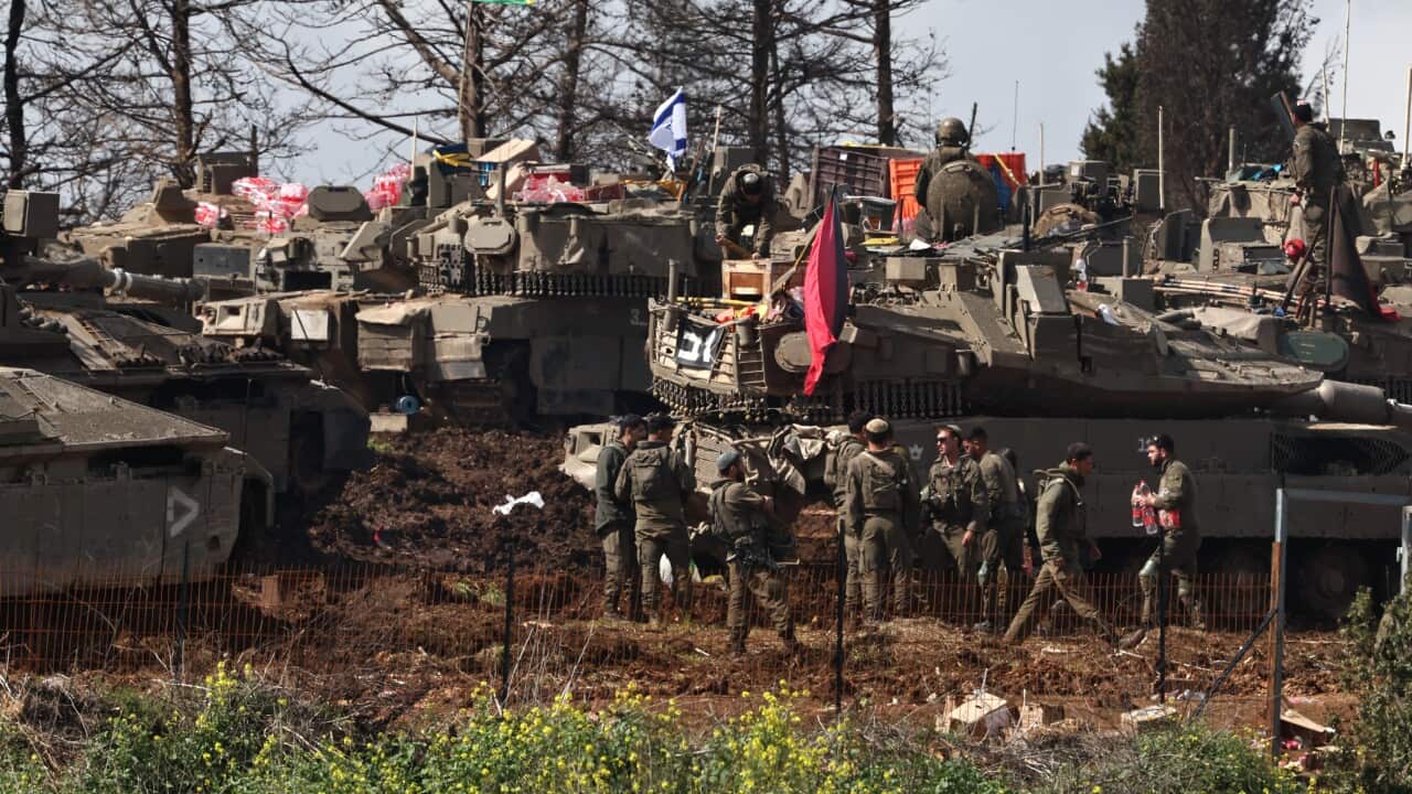 Troops in uniform and several tanks.