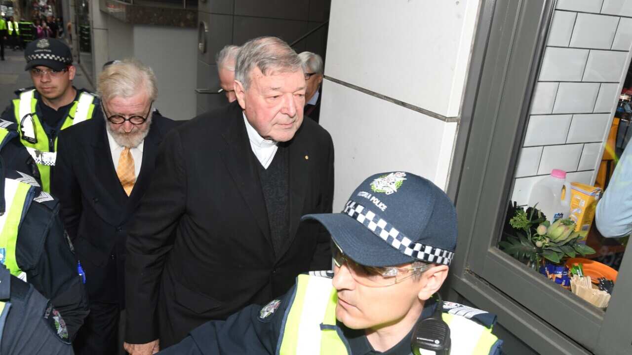 Cardinal George Pell escorted by police arrives at the Melbourne Magistrates Court in Melbourne on Friday, October, 6, 2017.