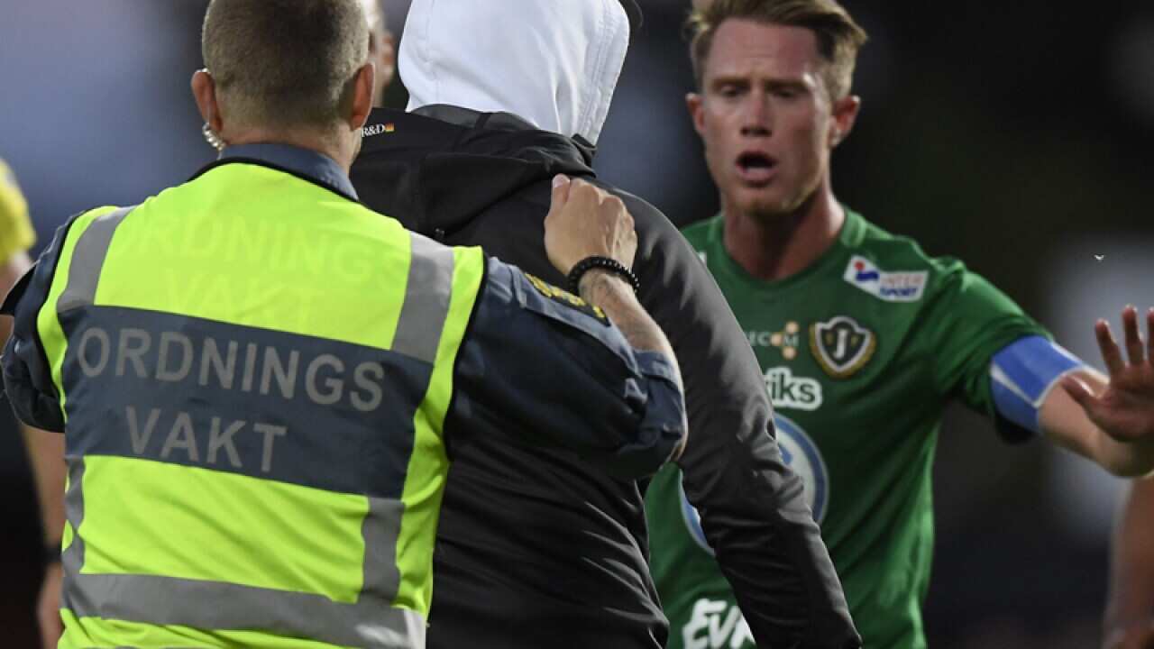Security officials try to detain a masked fan (2L)