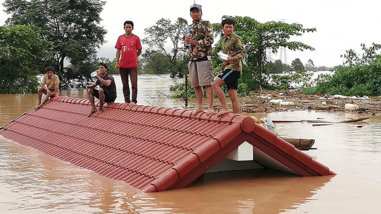 Villagers take refuge on a rooftop above flood waters from a collapsed dam in the Attapeu district of southeastern Laos, Tuesday, July 24, 2018.