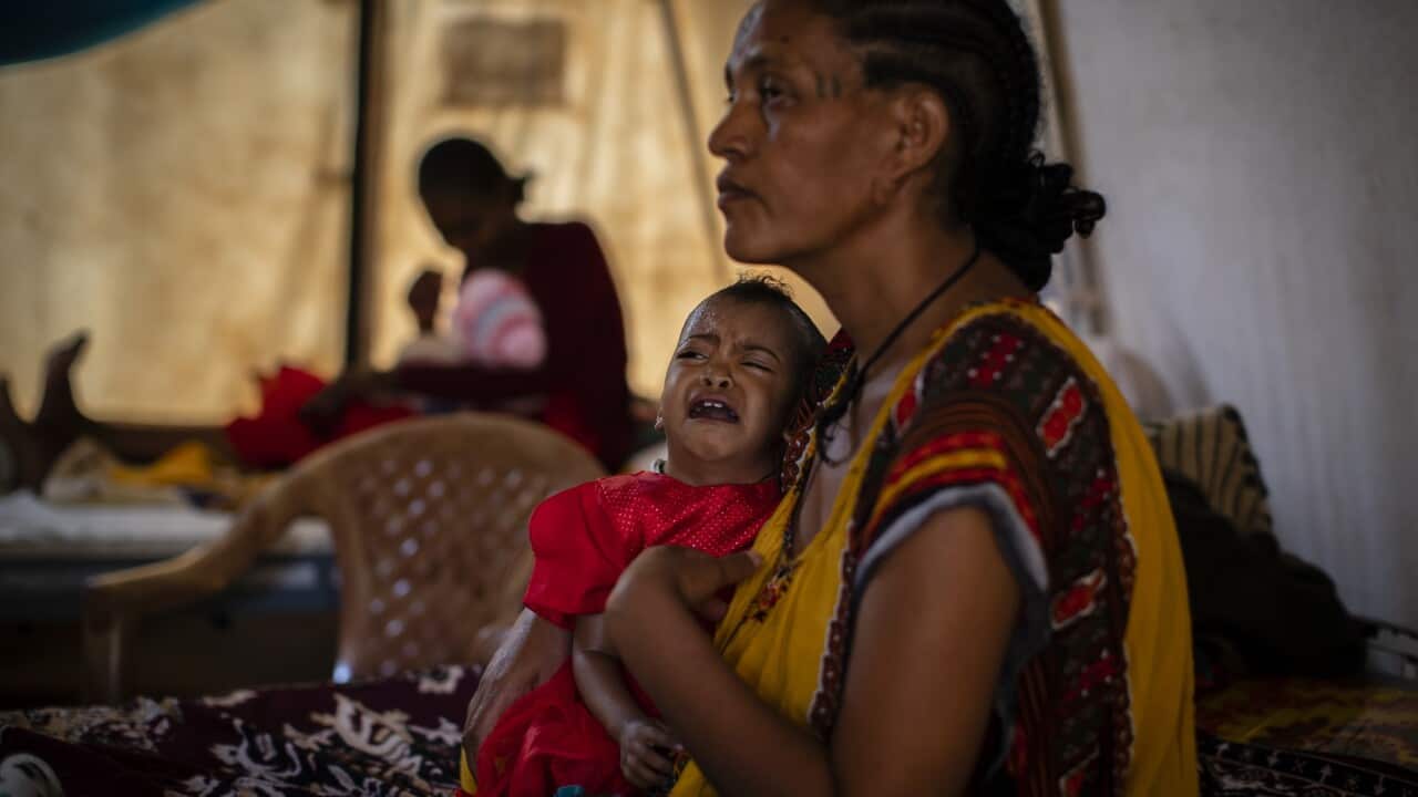 Roman Kidanemariam, 35, holds her malnourished daughter, Merkab Ataklti, 22 months old.