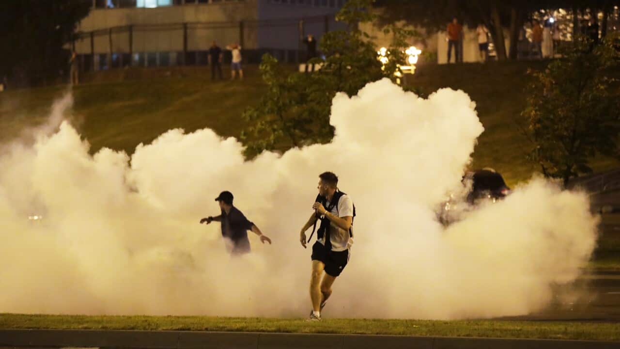 Protesters run through smoke during mass protests after the Belarusian presidential election in Minsk, Belarus.