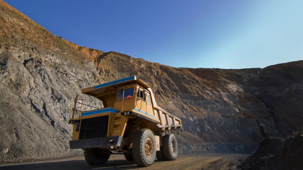 Large dump trucks on quarry road.