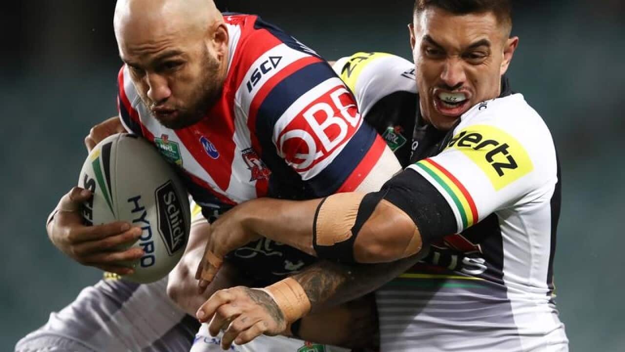 Blake Ferguson of the Roosters is tackled by the Panthers defence.