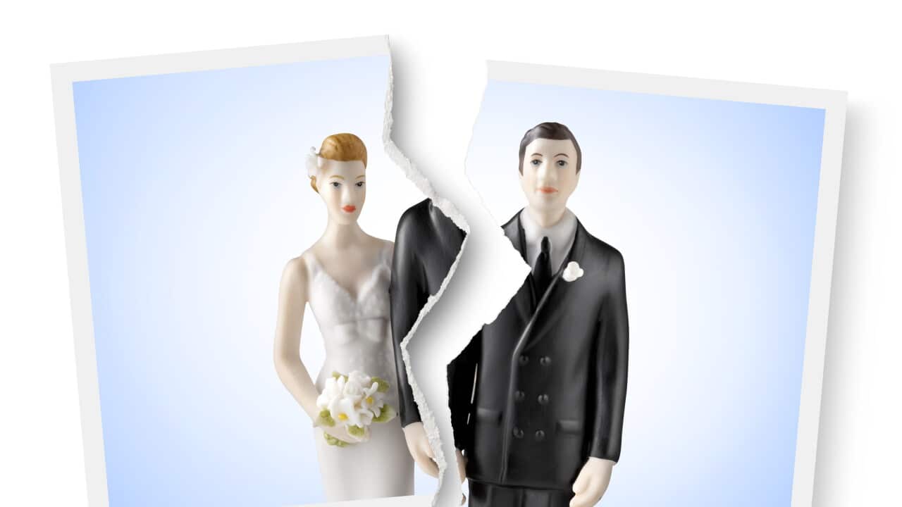 Divorce. Torn photograph of wedding cake topper.