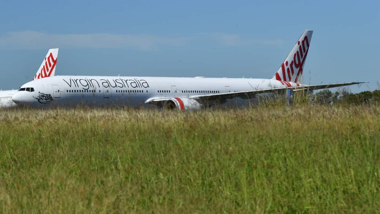Grounded Virgin Australia aircraft are seen parked at Brisbane Airport in Brisbane, Friday, April 17, 2020. (AAP Image/Darren England) NO ARCHIVING